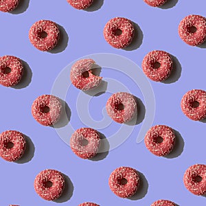 Pink Donut pattern on purple background. Sunlight minimal trendy concept. Top view