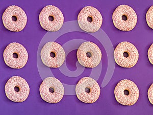 Pink donuts with white sprinkles pattern on purple