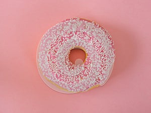 Pink donuts with white sprinkles on pink