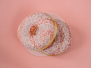 Pink donuts with white sprinkles on pink