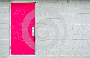 Pink door in a gray wall