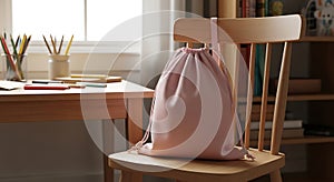 Pink drawstring bag on wooden chair image