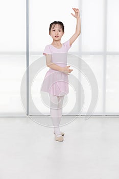 Pink dressed Asian girl in a ballet pose