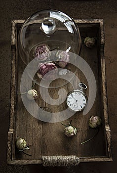 Pink dried roses in glass and wooden box photo