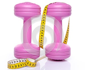 Pink dumbells with a tape measure