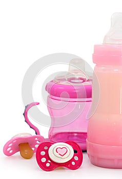 Pink dummies and bottles on white photo
