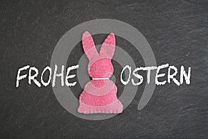 Pink Easter bunny with text `Frohe Ostern` on a chalkboard background.  Translation: `Happy Easter`.