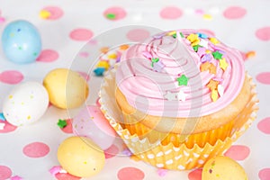 Pink Easter cupcake with candy and sprinkles