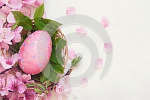 Pink easter egg in basket on white background