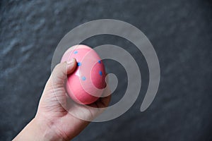 Pink easter egg hunt in Kids hand dark background