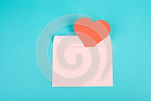 Pink envelope with a red heart, empty copy space, blue background, valintines day greeting card, romantic mail, love photo