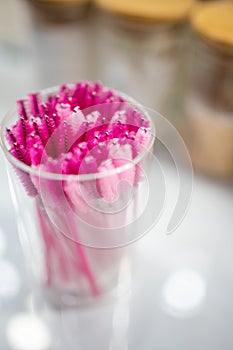 Pink eyelash brushes for eyelash extension in glass cup