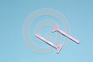 Pink female razors on the blue background. Pink women`s disposable razors. Epilation hair removal.