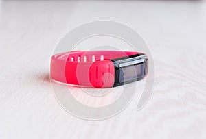Pink fitness bracelet with place for text on a white wooden background