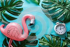 Pink Flamingo Inflatable with Alarm Clock and Sunglasses on Blue Water Background