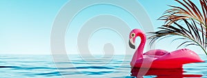 Pink flamingo inflatable in water with palm leaf decoration and blue sky background