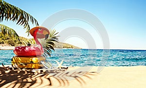 Pink Flamingo with luggage on the beach with beautiful sea view and copy space.