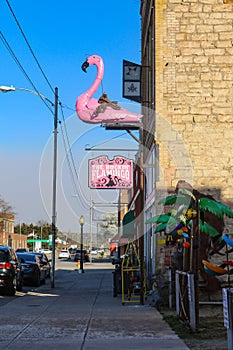 Pink Flamingo with saddle and eyeglasses metal statue outside The Bucking Flamingo store on Main Street in small American town of