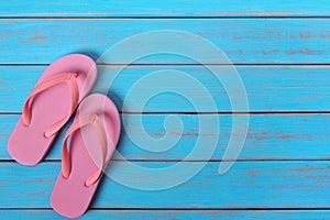 Pink flip flop sandals old summer beach wood background painted blue