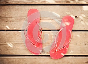 Pink flip flop sandals on wood