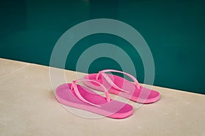 Pink flip flops at the edge of an indoor pool