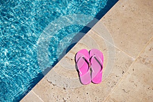 Pink flipflop on the granite poolside while vacation at the hotel