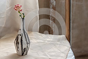 Pink flower in Black and White handmade ceramic vase and on Blush textured table cloth