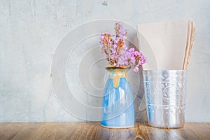 Pink flower in blue vase on a wooden table