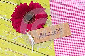 Daisy Gerbera blossom with gift tag with german word, Auszeit, means timeout or relax