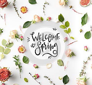 pink flowers, petals and figs aroung WELCOME SPRING lettering