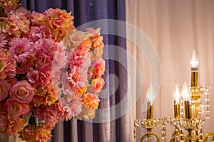 The pink flowers in the room with the electronic candle light with gray curtain , romantic retro style, lowkey.