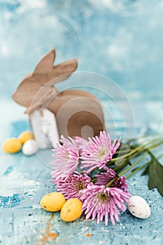 Pink flowers and yellow and white colored easter eggs, and easter bunny