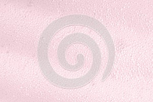 Pink foam macro background with bubbles. Soapy surface closeup. Foamy cleansing skin care product texture from soap