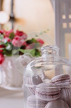 Pink french macarons under the glass on the wooden boards, soft focus background. Sweet desert In the cafe.