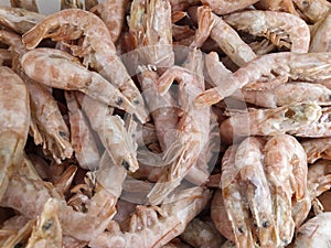 Pink fresh frozen shrimps with ice in a supermarket or fish shop. Uncooked seafood close up background