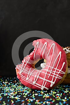 Pink frosted donut with bite missing