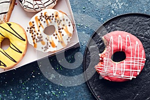 Pink frosted donut on dark background