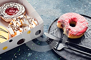 Pink frosted donut on dark background