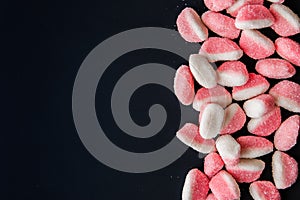 Pink fruit jellies at the right of the black background