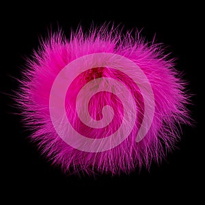 Pink fur pompom on black background