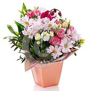 Pink gerberas, roses, eustoma and green leaves in a pink box on a white background.