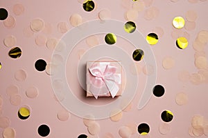 Pink gift box on a glitter pink background, birthday theme.