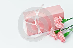 Pink gift box with pink carnations on table