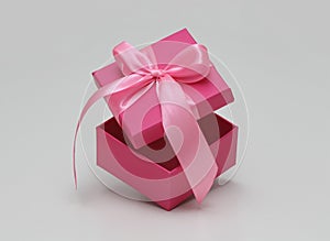 Pink gift box with satin ribbon. Open in motion. Space for goods and text. Unboxing process. Sale coupon template.