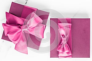 Pink gift box with silk bow on marble background, girl baby shower present and glamour fashion gift for luxury beauty brand,