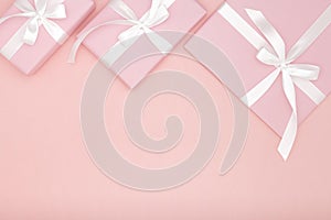 Pink gift or present box flat lay composition Valentine or women day, greeting card birthday with copy space on coral background.