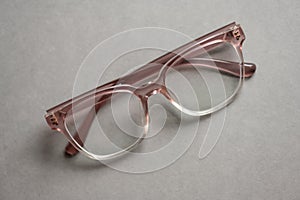 Pink glasses on grey background..