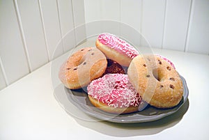 Pink glazed donuts on plate Wooden planks background