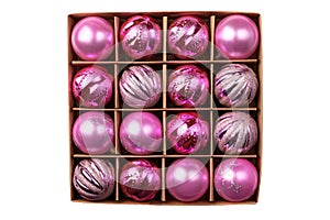 Pink glitter Christmas tree balls in cardboard box isolated on white background