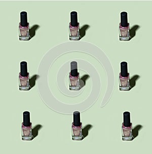 Pink glitter nail polish pattern on basil green background
